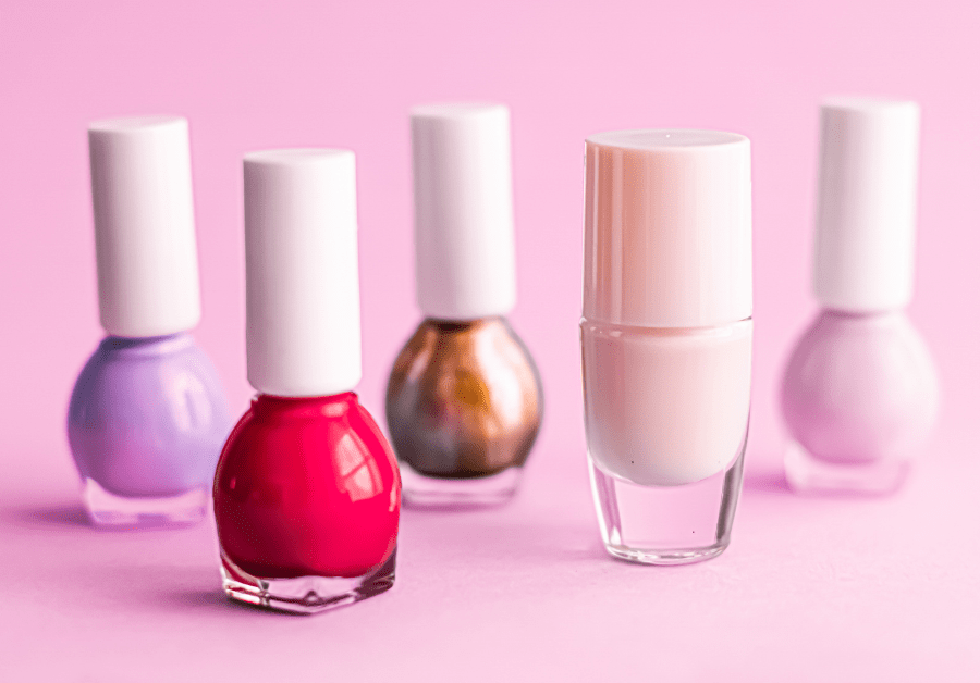 A variety of trendy nail polishes in pink, red, and nude shades — perfect nail color ideas for every season.