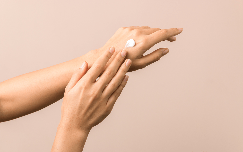Woman applying the best hand cream to keep her hands soft and hydrated through winter, spring, summer, and fall.