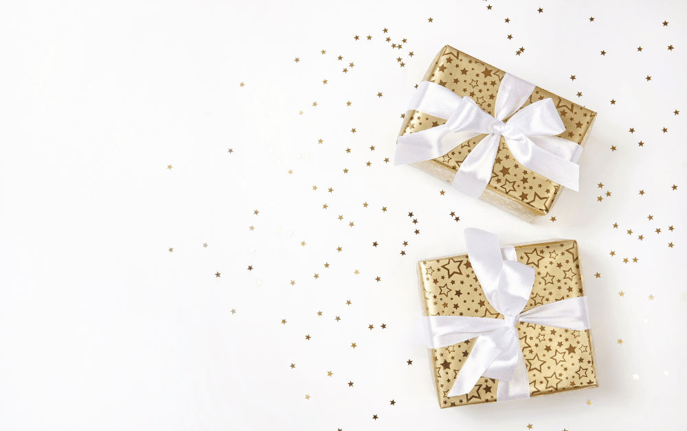 Shop for gift ideas. 2 gifts wrapped in white ribbon on a white background.