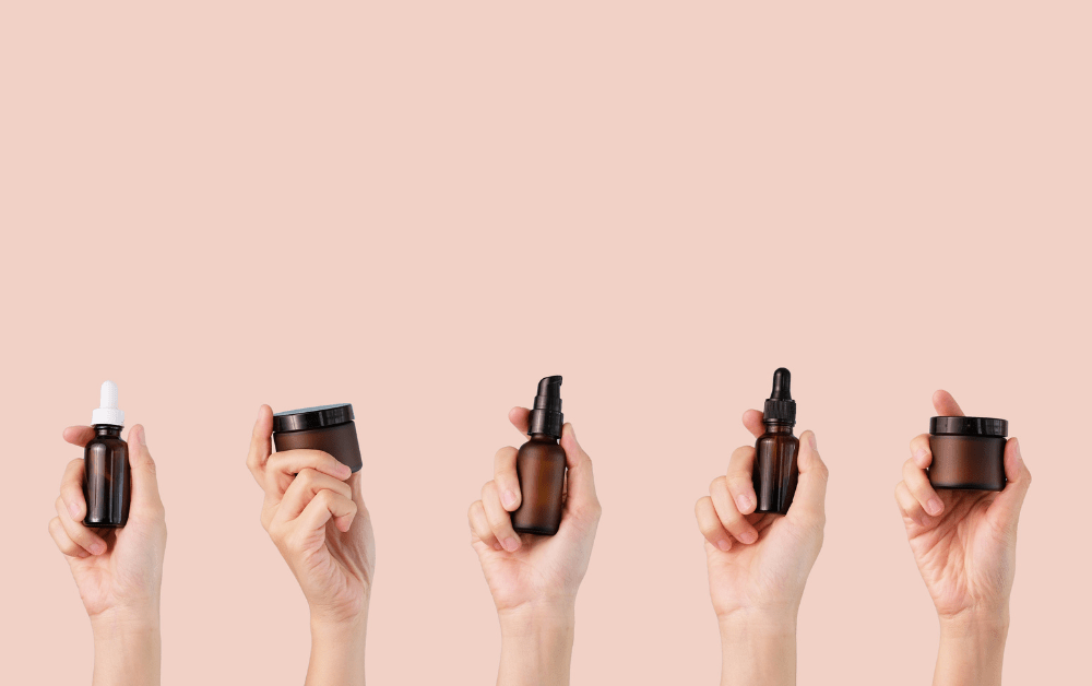 Skincare. Skincare products in hands in pink background.