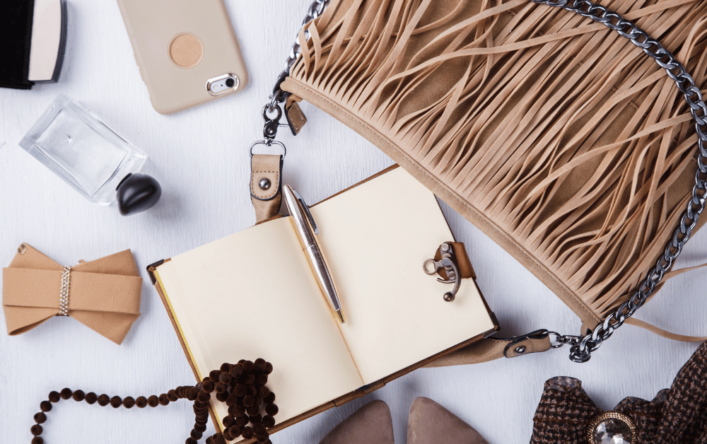 Chic bag styled with accessories jewelry, necklaces, basic accessories, and a journal; perfect self-care accessory and accessories ideas outfit for women.