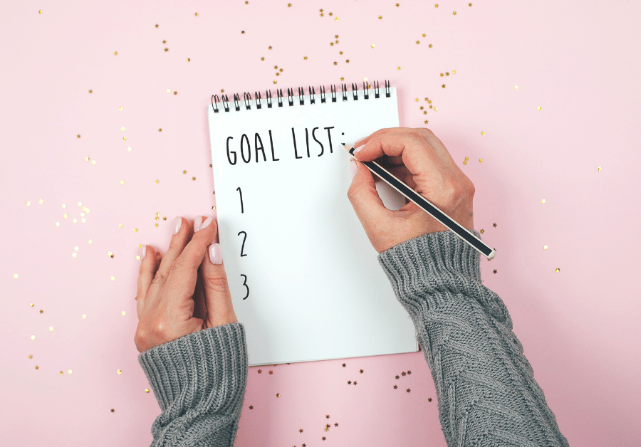 Person writing a goals list in a notebook, creating a calm workspace scene with goals inspiration ideas for planning and motivation.
