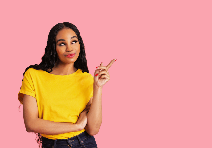 Smiling woman pointing to the side with a confident and cheerful expression, clean background and soft lighting, representing a guide on self-improvement and beauty with the theme how to glow up.