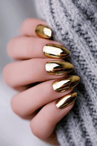 Close-up of gold nails with a glossy metallic finish and soft shimmer, creating a luxurious and festive manicure ideal for elegant New Year’s nails.