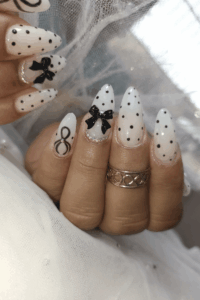 A woman wearing polka dot nails as part of spring nail ideas.