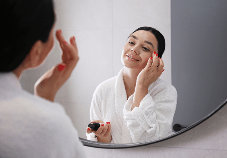 Woman applying skincare while following her night routine list before bed.