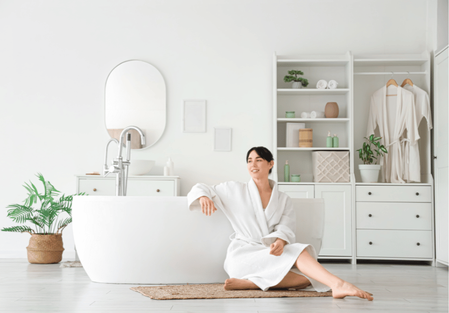 A woman relaxing in a cozy robe in her bedroom during a spa day at home.